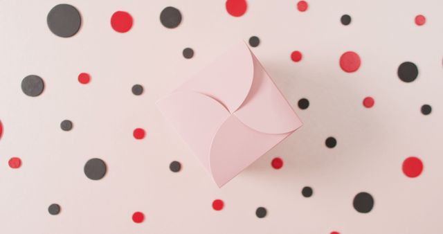 Overhead view of pink gift box on white background with red and black dots - Download Free Stock Photos Pikwizard.com