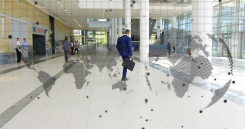 Businessman Walking in Modern Office with Global Map Overlay