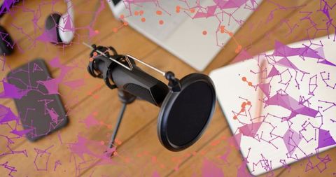 Recording podcast microphone on wooden desk with laptop and pop filter for home studio