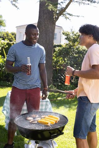 Diverse Friends Barbecuing in Backyard Enjoying Summer