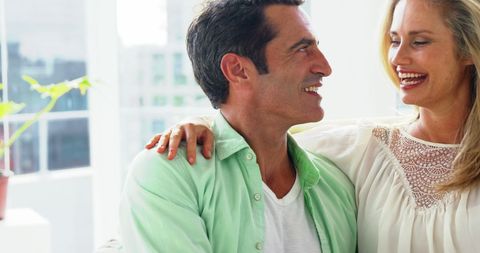 Happy Couple Embracing Playfully in Sunlit Living Room