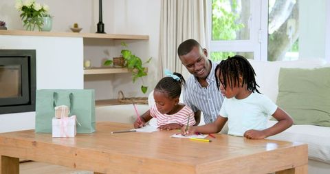 Father encouraging kids artistic skills in cozy living room