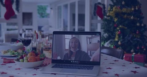Virtual Christmas Dinner Reunion Smiling Woman Waving on Laptop at Festive Dining Table