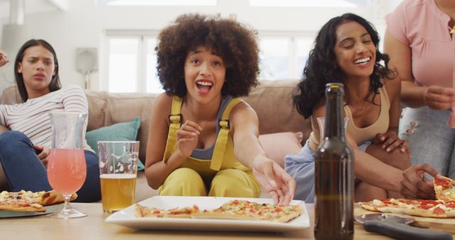 A group of diverse friends enjoying pizza and refreshments in a living room setting. One friend reaches for a slice, while others are laughing and engaged in lively conversation. This vibrant and cheerful scene works well for promotions related to friendship, social gatherings, parties, or casual dining. Ideal for lifestyle blogs, social media posts, and advertisements for food and beverages.