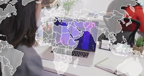Coworkers collaborating on laptop with world map overlay for global business teamwork