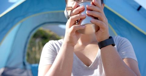 Woman Enjoying Refreshment During Mountain Camping Adventure