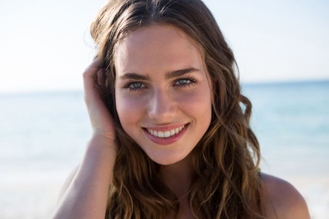 Portrait of smiling beautiful woman at beach on sunny day