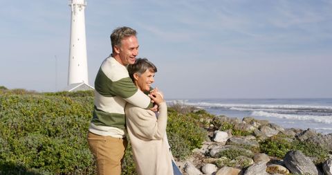Senior Couple Embracing Near Lighthouse by Ocean - Download Free Stock Images Pikwizard.com