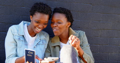 Sisters Enjoying Fun Moment Sharing Mobile Phone