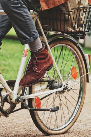 Urban Commuter Riding Bicycle with Red Suede Shoes and Metal Basket