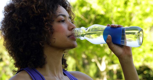 Woman Drinking Water from Bottle in a Sunny Park - Download Free Stock Images Pikwizard.com