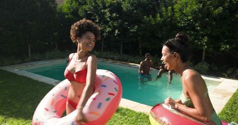 Friends Enjoying Summer Pool Fun with Inflatable Doughnut Floaties