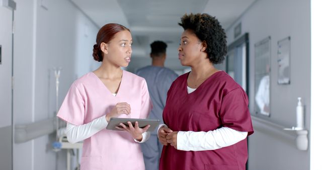 Healthcare Professionals Discussing Patient Care in Hospital Corridor - Download Free Stock Images Pikwizard.com