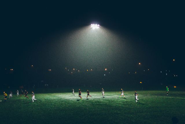 Soccer Players Competing in Night Match Under Bright Stadium Lights - Download Free Stock Photos Pikwizard.com