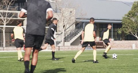 Soccer players training on field, rallying for play