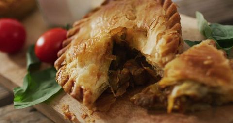 Savory Meat Pie on Wooden Board with Fresh Tomatoes