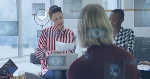 Leading woman reading documents holding laptop in collaborative meeting with hud overlays