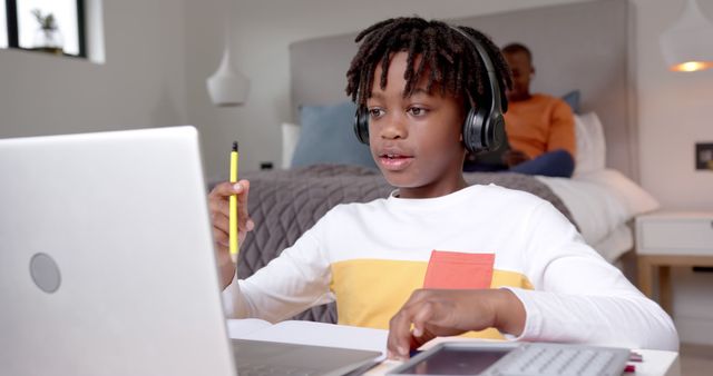 African American Boy Using Laptop at Home, Wearing Headphones for Online Learning - Download Free Stock Images Pikwizard.com