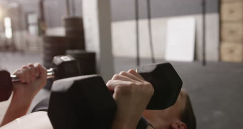 Focused Athlete Lifting Dumbbells During Workout at Gym