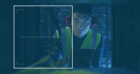 Technician Inspecting Data Center Equipment on Tablet