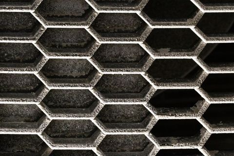 Hexagonal Metal Grille Honeycomb Pattern Showing Dust, Rust and Industrial Texture