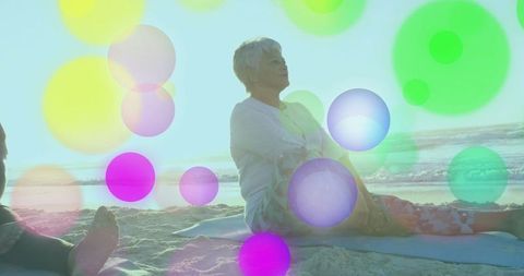 Senior hispanic woman practicing beach yoga at sunrise