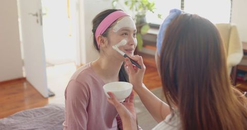 Mother and Daughter Skincare Ritual in Cozy Bedroom Setting