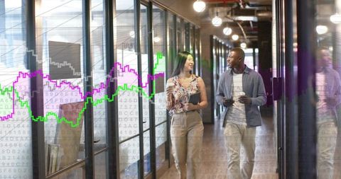 Coworkers walking with coffee and tablet in glass corridor with financial charts overlay