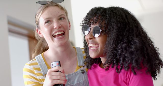 Happy diverse teenage female friends dancing and singing karaoke at home - Download Free Stock Photos Pikwizard.com