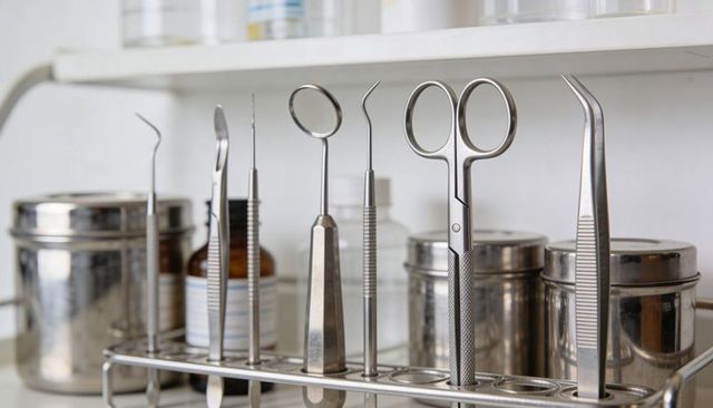 Stainless dental instruments standing in rack with mirror probes tweezers scissors clinic