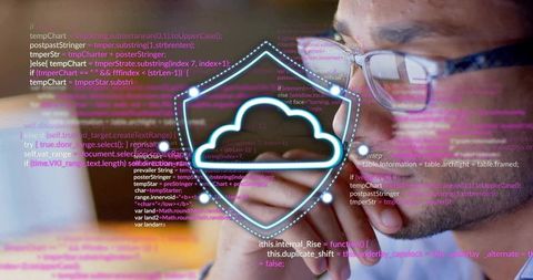 Focused developer studying cloud security code with glowing shield overlay for cybersecurity