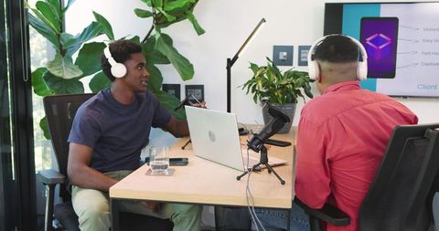 Diverse coworkers collaborating in office podcast recording