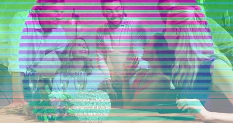 Adults gathering around cake celebrating birthday at home laughing and clinking glasses