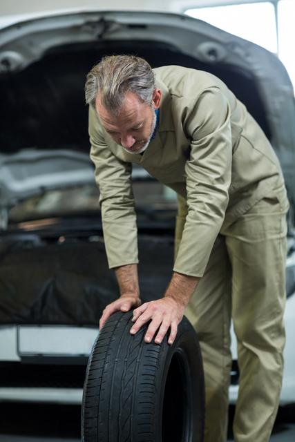 Mechanic looking at tyre in repair garage