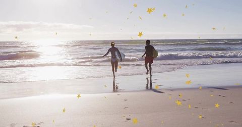 Adventurous surfers running to ocean at sunset