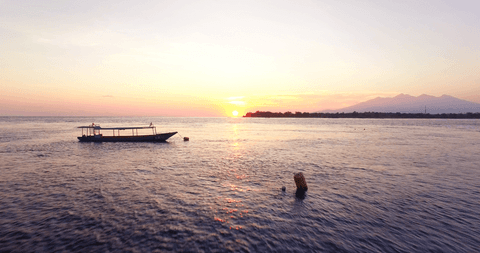 peaceful boat silhouette on sea during transparent sunset - Download Free Stock Videos Pikwizard.com