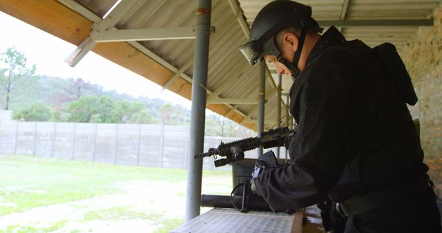 Police officer wearing tactical gear preparing rifle in an outdoor shooting range. Officer focused on weapon preparation. Suitable for law enforcement training materials, security firms, weapon safety courses, or tactical equipment promotions.