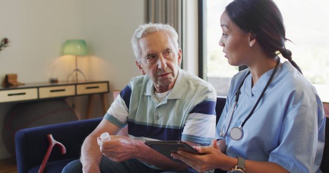 Senior Man Consulting with Nurse at Home Using Digital Tablet - Download Free Stock Images Pikwizard.com