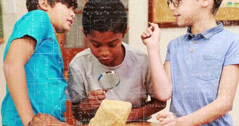 Curious students examining rock specimen with magnifier during hands-on classroom science