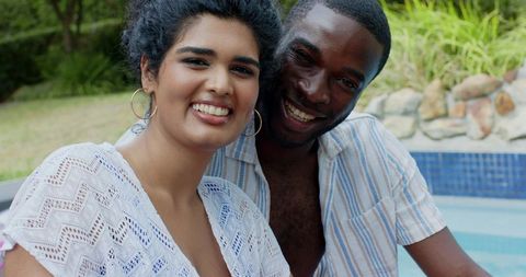 Smiling couple leaning poolside enjoying summer together candid backyard leisure portrait