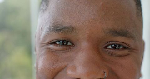 Close-up portrait of african american man with nose hoop ring and warm eye contact