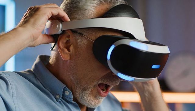 Older man adjusting virtual reality headset reacting to immersive home gaming experience