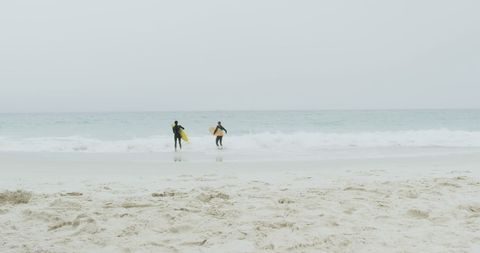 Surfers with Boards Heading to Ocean Waves on Misty Day - Download Free Stock Images Pikwizard.com