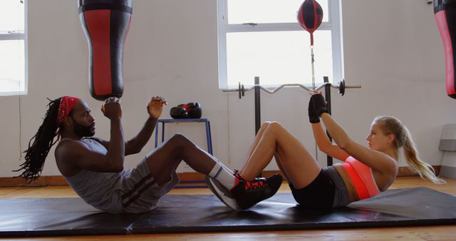 A fitness trainer assists a client with an ab workout, emphasizing health dedication. - Download Free Stock Photos Pikwizard.com