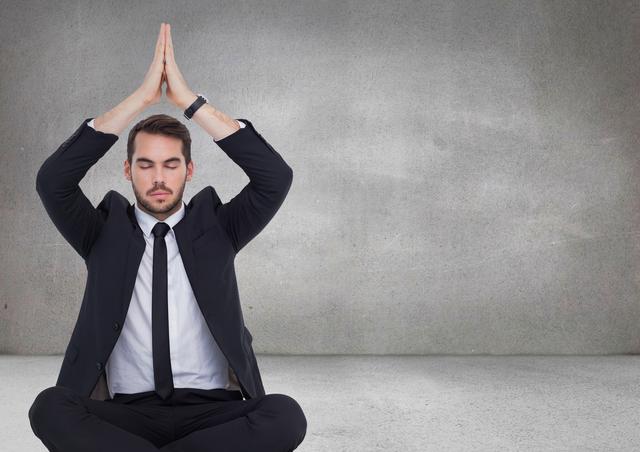 Digital composite of Business man meditating with hands over head against grey wall