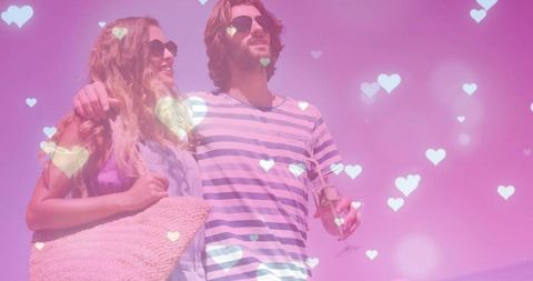 Couple enjoying romantic beach getaway with heart bokeh and pink summer glow