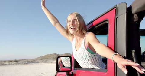Joyful Road Trip Adventure: Smiling Woman Enjoys Coastal Drive