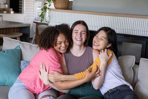 Diverse Female Friends Embracing on Stylish Living Room Sofa
