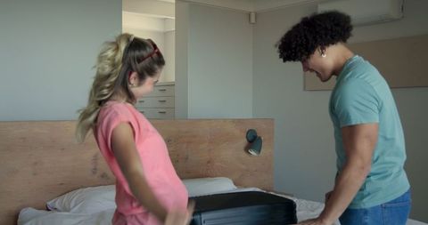Young Couple Packing Suitcase for Andventurous Vacation