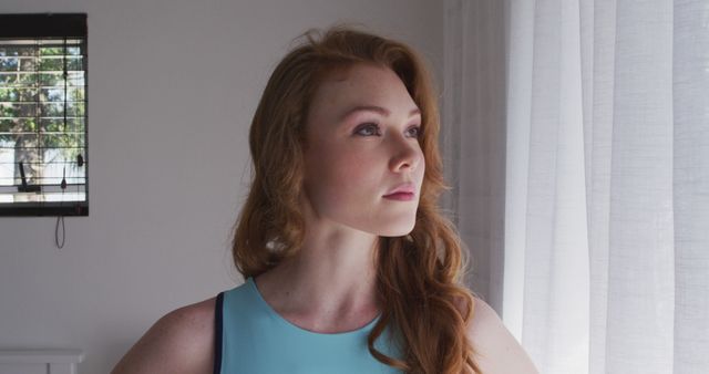 Confident Redheaded Woman Standing by Window in Bright Room - Download Free Stock Images Pikwizard.com